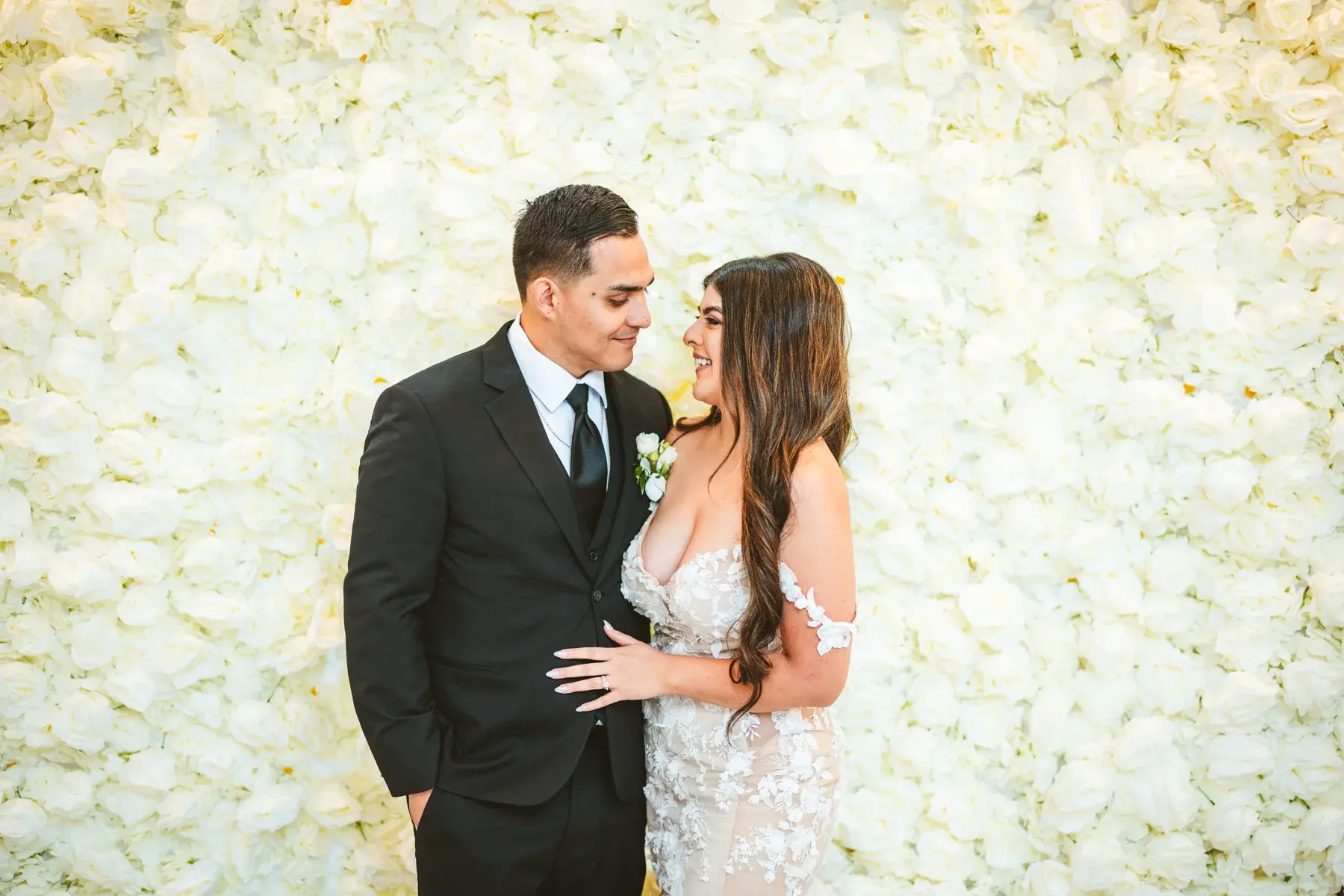Wedding portrait in front of the white rose flower wall